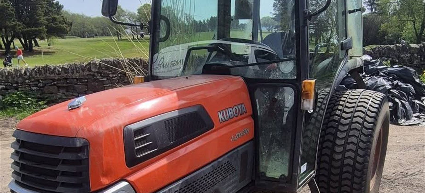 A Kubota L5030 compact tractor at the edge of a golf course in Lancashire